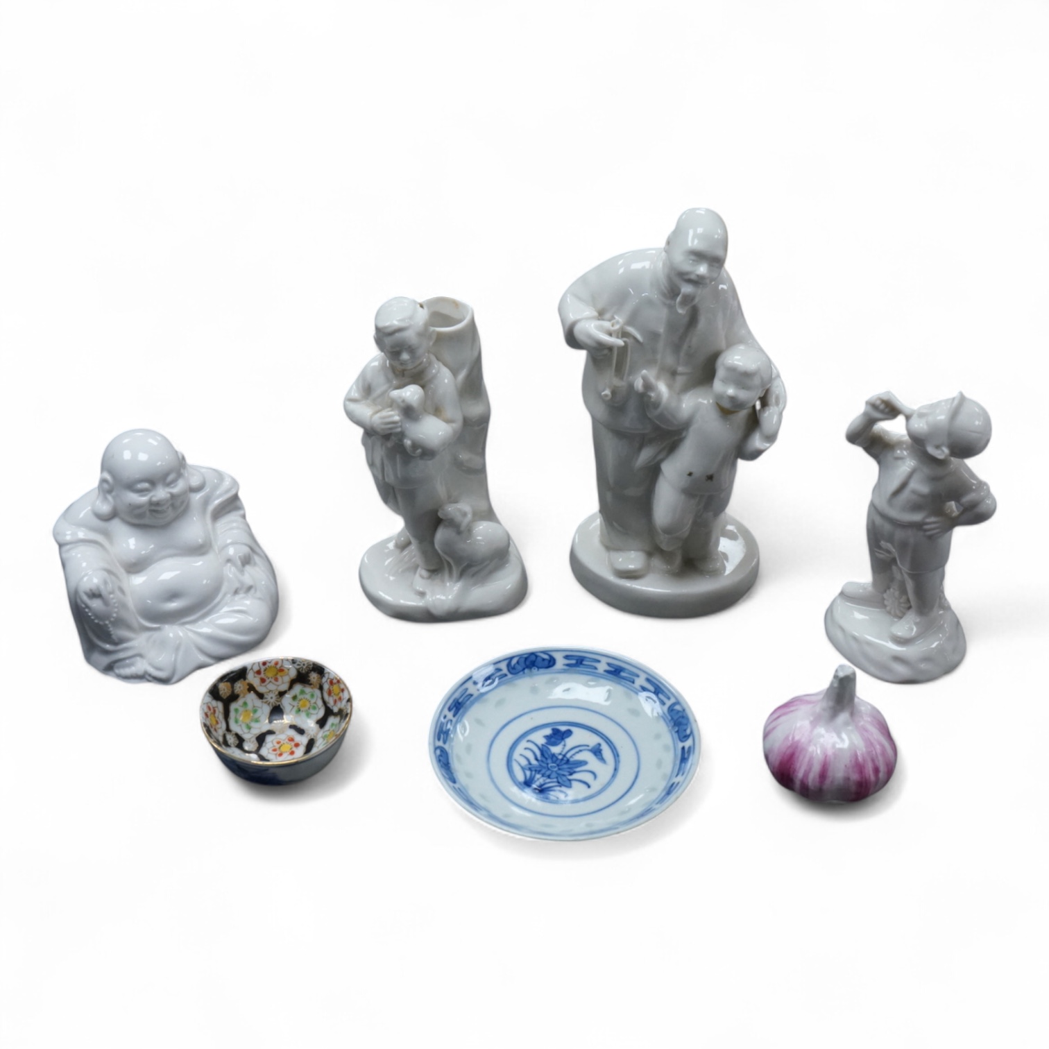 Four Chinese blanc de chine figures and two blue and white dishes and a model of a garlic bulb. Tallest figure 17.5cm.
